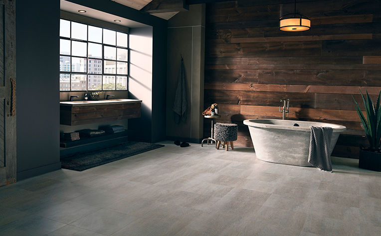 Open concept bathroom with light tile floor, wood plank wall, and free standing tub and sink